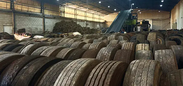 Pneus inservíveis recebidos e empilhados para triagem no galpão industrial